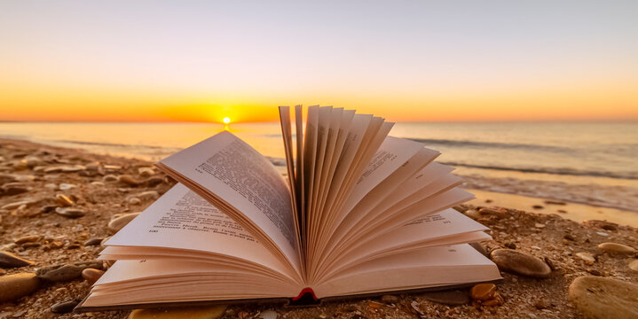 Livre ouvert sur les galets au coucher du soleil, Étretat village d'écrivains
