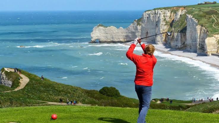 Golfeur en plein swing au-dessus des falaises et de la mer à Étretat