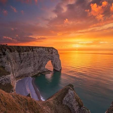 Coucher de soleil embrasé sur la Manneporte et les falaises d'Étretat